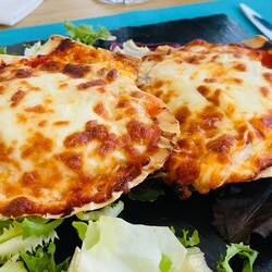 Stockfisch mit Käse überbackene Jakobsmuschel. Leider war das Fleisch der Muschel nicht zu finden.