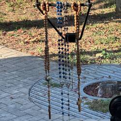 Five rosaries hanging in the window of the bus driven by Alexander the Great