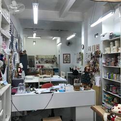 Tolles Handarbeitsgeschäft: eine Mitarbeiterin bringt jungen Menschen bei Taschen aus Jeans zu nähen