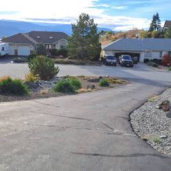 View of the front yard (zero-scaping) with Lake Okanagan in the background.