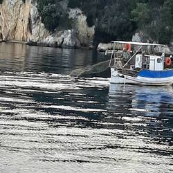 Fisherman laying his net near Gouvia