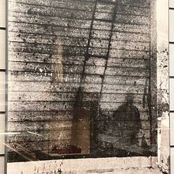 Shadow of Ladder Burned Into Stone Building