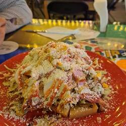 Cabimera (venezuel.): Aretas (Maismehlfladen) gehäuft mit Salat, Fleisch, Ei, Käse und Soßen