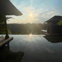 The sun reflected in one of the infinity pools of the Mandapa Ritz Carlton