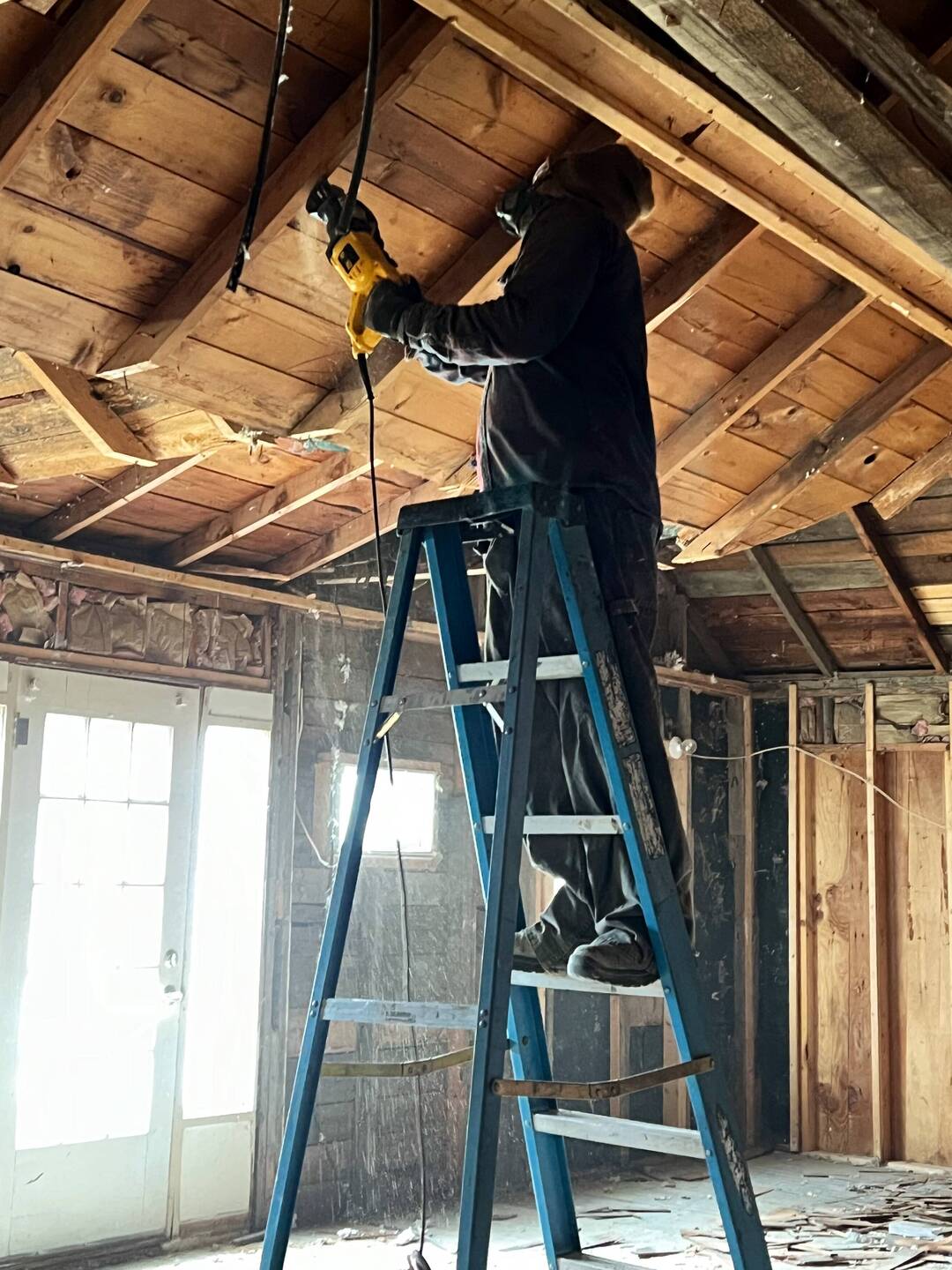 Brice using sawmill to take out the sections of ceiling that open up into the attic.
