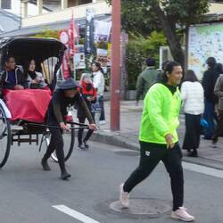Der Rikschafahrer und sein Vorläufer, der ihm den Weg frei macht.