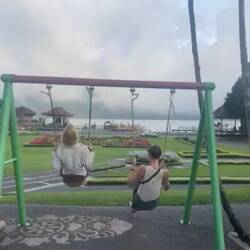 Lara and I having fun on a too small children's swing in Pura Ulun Danu Bratan