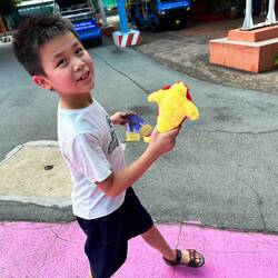 Jemand ist sehr glücklich mit seinem Trostpreis vom Pfeile werfen