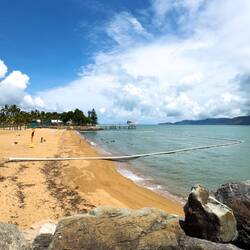 The white boom encircles a netted stinger pool for safe swimming — Townsville, QLD.