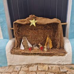 Een klein kerststalletjes bij de ingang van een huis