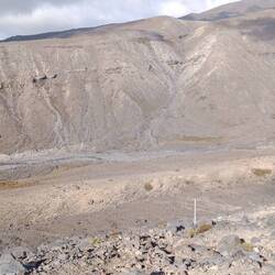 a deep valley with a small bridge barely visible on the right side