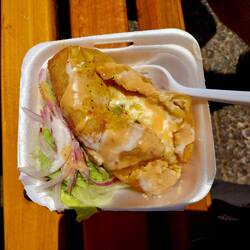 Gekochte, fritierte Kartoffel mit verschiedenen Soßen und Salat