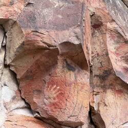 Oben in schwarz ein Guanako und unten die vier schwarzen Linien sind die "Lassos" mit Steinen dran