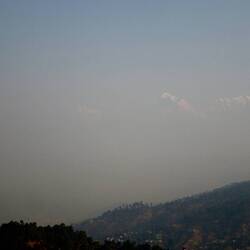 Die schneebedeckten Berggipfel des nahe gelegenen Himalaya sind nur schemenhaft zu erkennen.