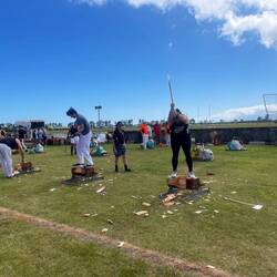 Log cutting, men and women. Theystand on the log and chop between their legs.
