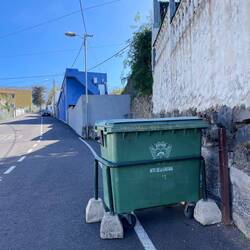 Bei steil verlaufenden Strassen werden die Müllcontainer mit Betonblöcken fixiert.