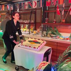 zur Musik von Traumschiff wird die Torte hereingefahren von der Hoteldirektorin Heidi Rothe
