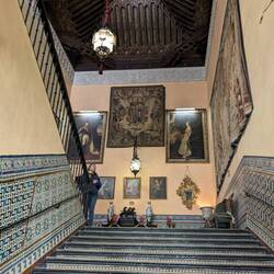 The grand stairway with tapestries, paintings, tiles, and an incredible ceiling