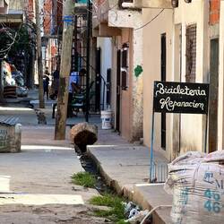 rechts ein Sack für Abraum, aber auch neues Baumaterial wird so geliefert, dahinter Velowerkstatt