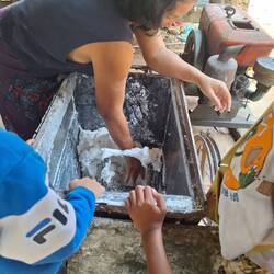 Rice noodle making: ground into flour and then put through a sieve into boiling water