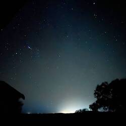 Der Nachthimmel. Am Horizont leuchtet Geraldton