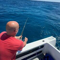 Chris zieht den ersten Fang an Land. Mit einem extra dafür gemachten Gürtel für die Rute