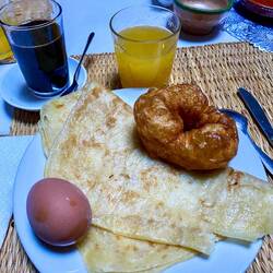 Breakfast of boiled egg, Moroccan pancake, and beignet