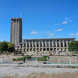 Rathaus mit großem Platz und viel Grün und Springbrunnen davor