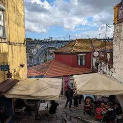There was a man grilling fish on a ¿radiator? under that umbrella
