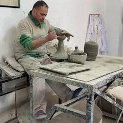 Expert craftsman, turns the pottery wheel with his legs