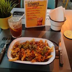 Pommes mit Chili con Carne und Jalapenos, gut scharf. Dazu ein Zitronensaft-Mineralwasser-Eis-Kaffee