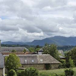 Mauezin church with Pyrénées shrouded in cloud