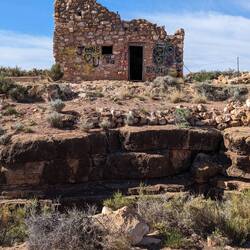 The cave entrance is in the hole in front of this house