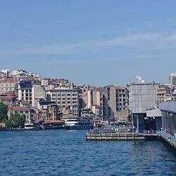 Looking back towards Asian side of Istanbul, Galata tower on left. Fisherwomen and men on bridge.