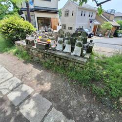 Statues w white aprons. Perhaps an altar to Jizo, Buddhist patron deity of children & travelers.