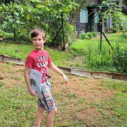 Monikas Sachkundeschüler Lucien, im Hintergrund unser Zuhause in Ukarumpa