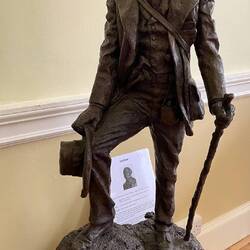 A bronze if Charles zoom in to see the Galapagos animals and tool around his waist.