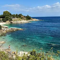 The beach in Kassiopi. Our loungers on the rocks are not easy to see but they are there.