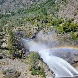Water leaving dam downstream with rainbow