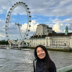 Vela standing in front of the London Eye