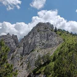 Oben auf dem Felsen sieht man die kleinen Menschen.