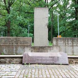 Kronvaldi Park; behind the small monument is a fragment of the Berlin Wall