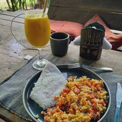 Hostelfrühstück: Rührei, Arepa de yuca (Maniok) con queso und Copoazúsaft