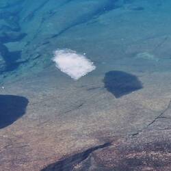 Eis wirft Schatten im glasklaren Wasser