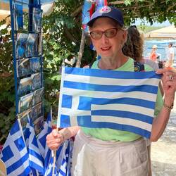 Shirley at the market in Fiskard. We only noticed later that was a "Greek protest flag".