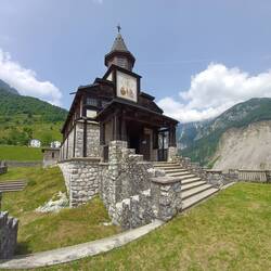 Glockenturm mit einer Sonnenuhr und der Innschrift PAX für Frieden