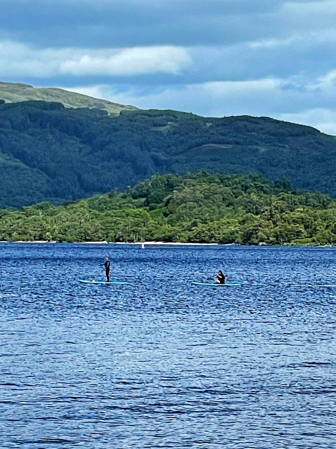 Lake Lomond and the Trossachs National Park. People canoeing and stand up paddle boarding.