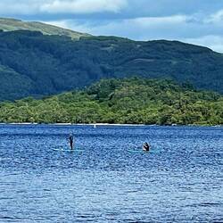 Lake Lomond and the Trossachs National Park. People canoeing and stand up paddle boarding.