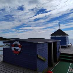 Am Ende vom Steg: Im Vordergrund Umkleidekabinen. Im Hintergrund eine Sauna. Natürlich.