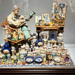 A miniature setting of an artist, new work vs old but it highlights the art of ceramics.